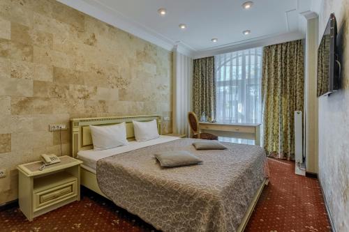 een hotelkamer met een bed en een televisie bij Vintage na Bulvare in Odessa