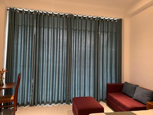 a living room with a couch and a large window at Kapaliya Unawatuna in Unawatuna