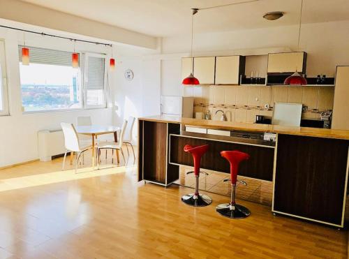 een keuken met rode krukken in het midden van een kamer bij Big and Modern Apartment in Timisoara North T34 in Timişoara