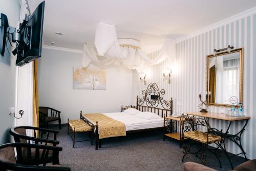 a bedroom with a bed and a table and a mirror at SPA-Hotel Dodo in Zhytomyr
