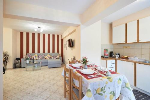 uma cozinha e uma sala de estar com uma mesa num quarto em ZafireniaSuites em Elevtheraí