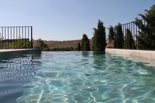 una piscina d'acqua di fronte a una recinzione di Casa Rural Torre del Homenaje a Belmonte