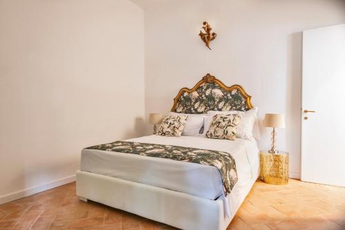 - une chambre avec un lit blanc et une tête de lit ornée dans l'établissement Tenuta di Megognano, à Poggibonsi