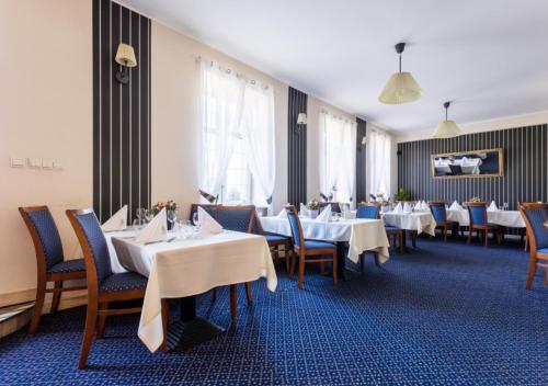 a dining room with white tables and chairs at Hotel Diamond w Białym Dworku in Rumia