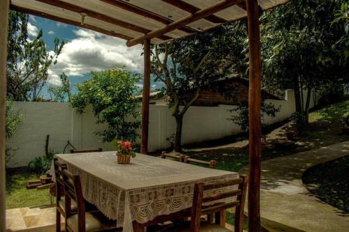 a table and chairs under a wooden pergola at Casa Campestre en Ibarra in Ibarra