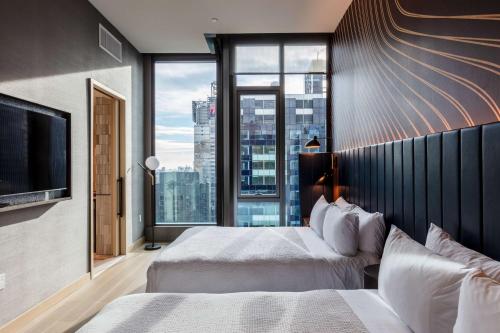 a hotel room with two beds and a large window at Tempo By Hilton New York Times Square in New York