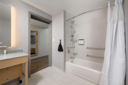a bathroom with a tub and a sink and a shower at Hyatt Place Albany Downtown in Albany