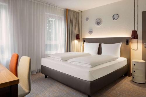 Кровать или кровати в номере Vienna House Easy by Wyndham Bad Oeynhausen