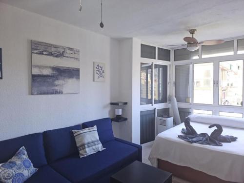 - un salon avec un canapé bleu et un lit dans l'établissement Garajonay studio apartment in the center of Torremolinos, à Torremolinos