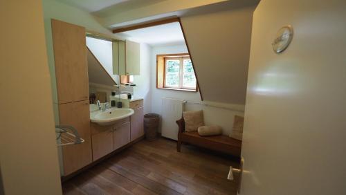 baño con lavabo, espejo y ventana en Haus Onel, en Schmallenberg