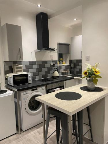 a kitchen with a washing machine and a table at DD Apartment 2 - Free Parking - Fast WifI in Castle Donington