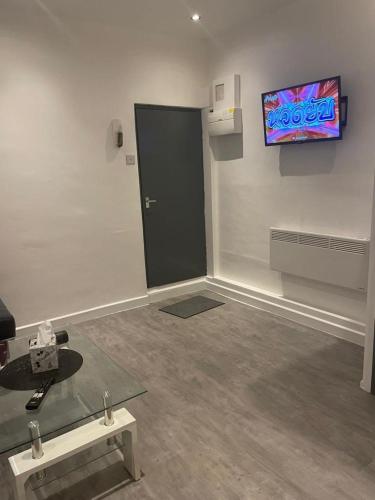 um quarto com uma porta preta e uma televisão na parede em DD Apartment 2 - Free Parking - Fast WifI em Castle Donington