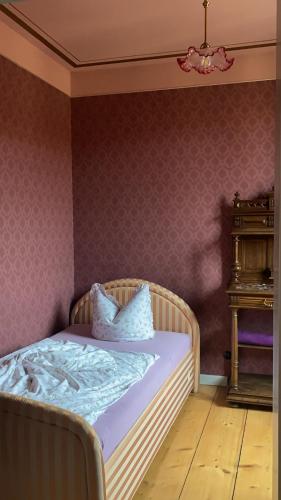 uma cama com duas almofadas num quarto em Altes Handelshaus Plauen em Plauen