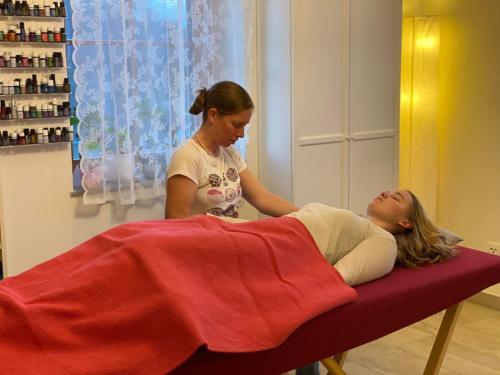 a woman getting a massage from a woman laying on a bed at Kellerstöckl am Gut Kunterbunt in Hartl