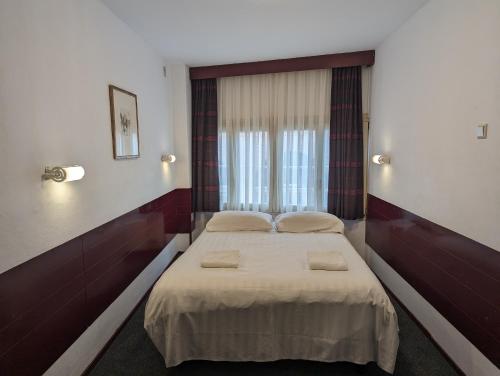 een slaapkamer met een bed met 2 kussens erop bij Budget Hotel Ben in Amsterdam