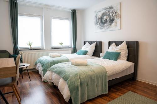 twee bedden in een kamer met twee ramen bij Volante Studio Bremen-Findorff in Bremen