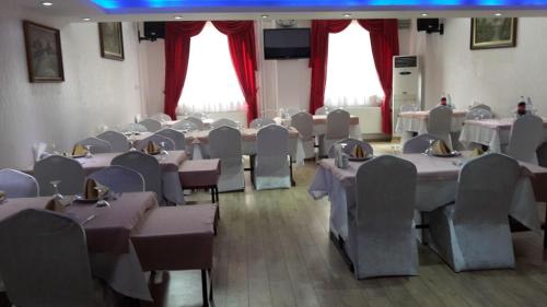 a large room with tables and chairs and tablesearcher at snowrose hotel in Şahinbey