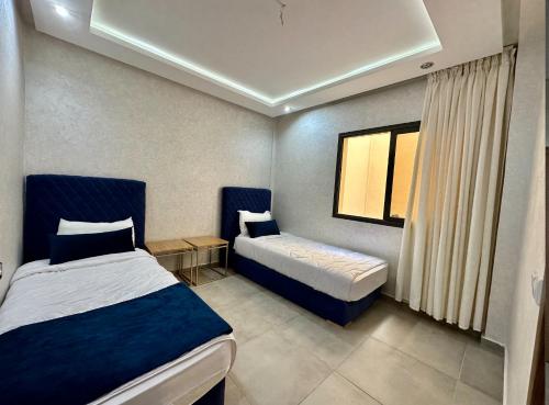 1 dormitorio con 2 camas y ventana en Moussa Residence, en Dakhla