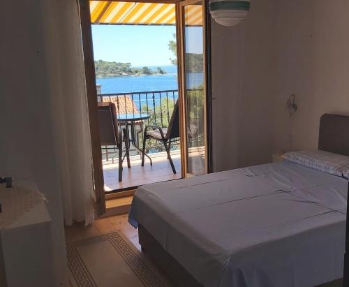 a bedroom with a bed and a balcony with a view at Apartment Maja in Mali Lošinj