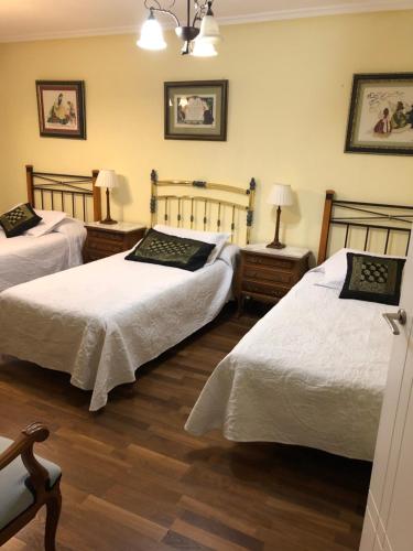 a bedroom with two beds and two tables with lamps at MENCIA in Mansilla de las Mulas