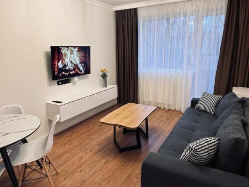 a living room with a couch and a table at Sun Clock Apartment in Šiauliai