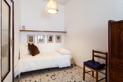 una camera con un letto bianco e una sedia di Casa Nina a Sorrento