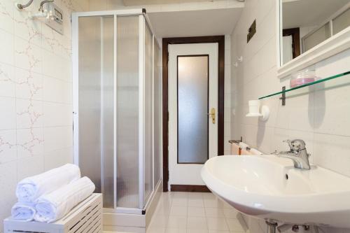 bagno bianco con lavandino e doccia di Casa Nina a Sorrento