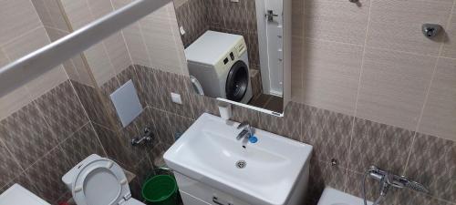 ein Badezimmer mit einem Waschbecken, einem WC und einem Spiegel in der Unterkunft Егизбаева 7/21 in Almaty