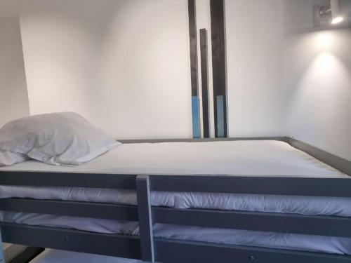 a bed in a room with a pillow on it at Hostel Faro Málaga modern & luxury in Málaga