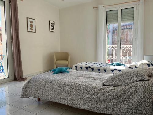 een slaapkamer met 2 bedden, een stoel en een raam bij La casa Marcel, maison de 110 m2 in Pia