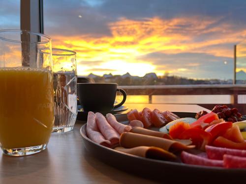 a plate of hot dogs on a table with a drink at Herøy Brygge 