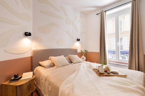 une chambre avec un grand lit et une fenêtre dans l'établissement Sirene - 2 chambres à Batignolles, à Paris