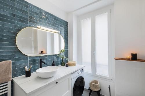 une salle de bain avec un lavabo et un miroir dans l'établissement Sirene - 2 chambres à Batignolles, à Paris
