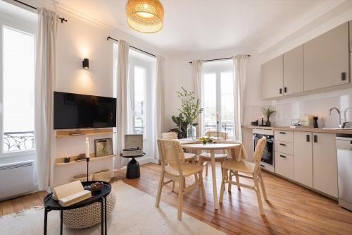 une cuisine et une salle à manger avec une table et des chaises dans l'établissement Sirene - 2 chambres à Batignolles, à Paris