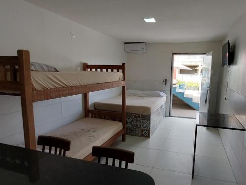 a room with two bunk beds and a door to a patio at Apartamentos Mobiliados in Aldeia