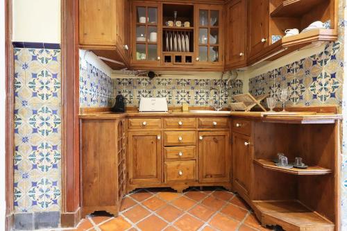 a kitchen with wooden cabinets and blue and white tiles at Estrela Panoramic Views by Homing in Lisbon