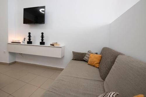 a living room with a couch and a flat screen tv at Hauzify I Apartamento Celeste in San Sebastián de la Gomera