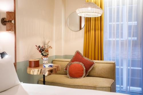 a bedroom with a couch and a table and a window at room2 Belfast Hometel in Belfast