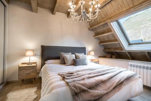 Un dormitorio con una cama grande y una lámpara de araña. en Casa Baqueira, en Betrén