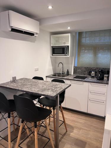 - une cuisine avec une table et des chaises noires dans l'établissement LE 47, à Strasbourg