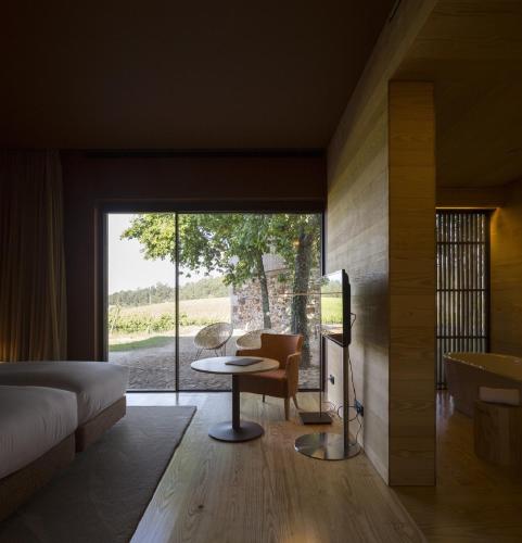 a bedroom with a bed and a table and a window at Monverde - Wine Experience Hotel - by Unlock Hotels in Amarante