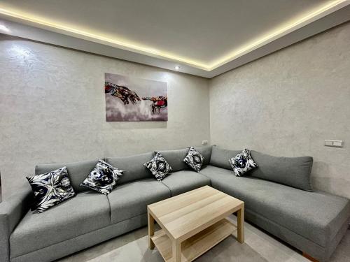 a living room with a gray couch with pillows at Moussa Residence in Dakhla
