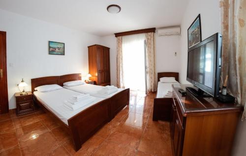 Villa MD في بودفا: غرفة نوم بسريرين وتلفزيون بشاشة مسطحة