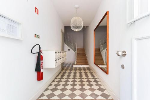 a hallway with a checkered floor and a red fire hydrant at Alfama Deluxe by Homing in Lisbon