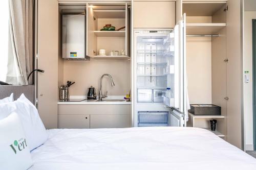 a bedroom with a bed and a sink and a kitchen at Hotel Vert in Seoul