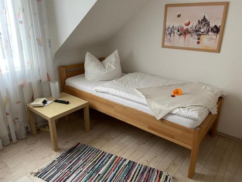 a small bedroom with a bed and a table at Hotel Garni-Tell in Siegen