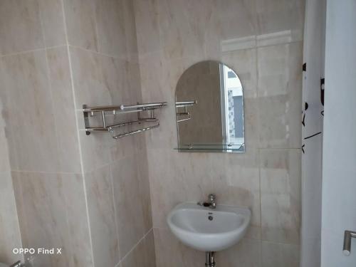 ein Bad mit einem Waschbecken und einem Spiegel in der Unterkunft Apartemen Skylounge Makassar in Manda
