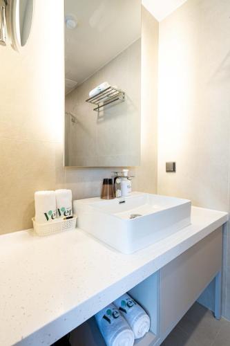 a bathroom with a white sink and a mirror at Hotel Vert in Seoul