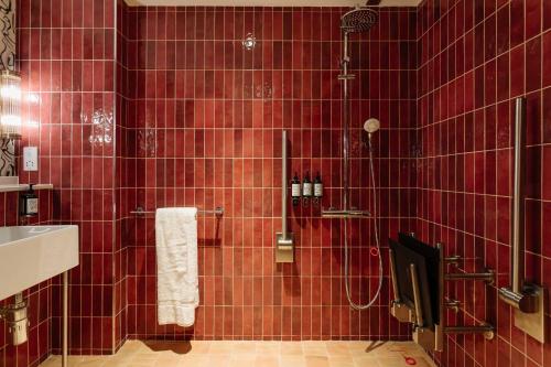 a red tiled bathroom with a shower and a sink at room2 Belfast Hometel in Belfast