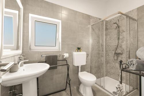 a bathroom with a toilet and a sink and a shower at Apartman Dobrec in Poreč